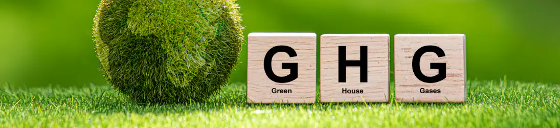 芝生の上に木製ブロックで『G』『H』『G』と書かれた立方体が並び、それぞれにGreen、House、Gasesの文字が添えられている。温室効果ガス（GHG）を表すイメージ画像